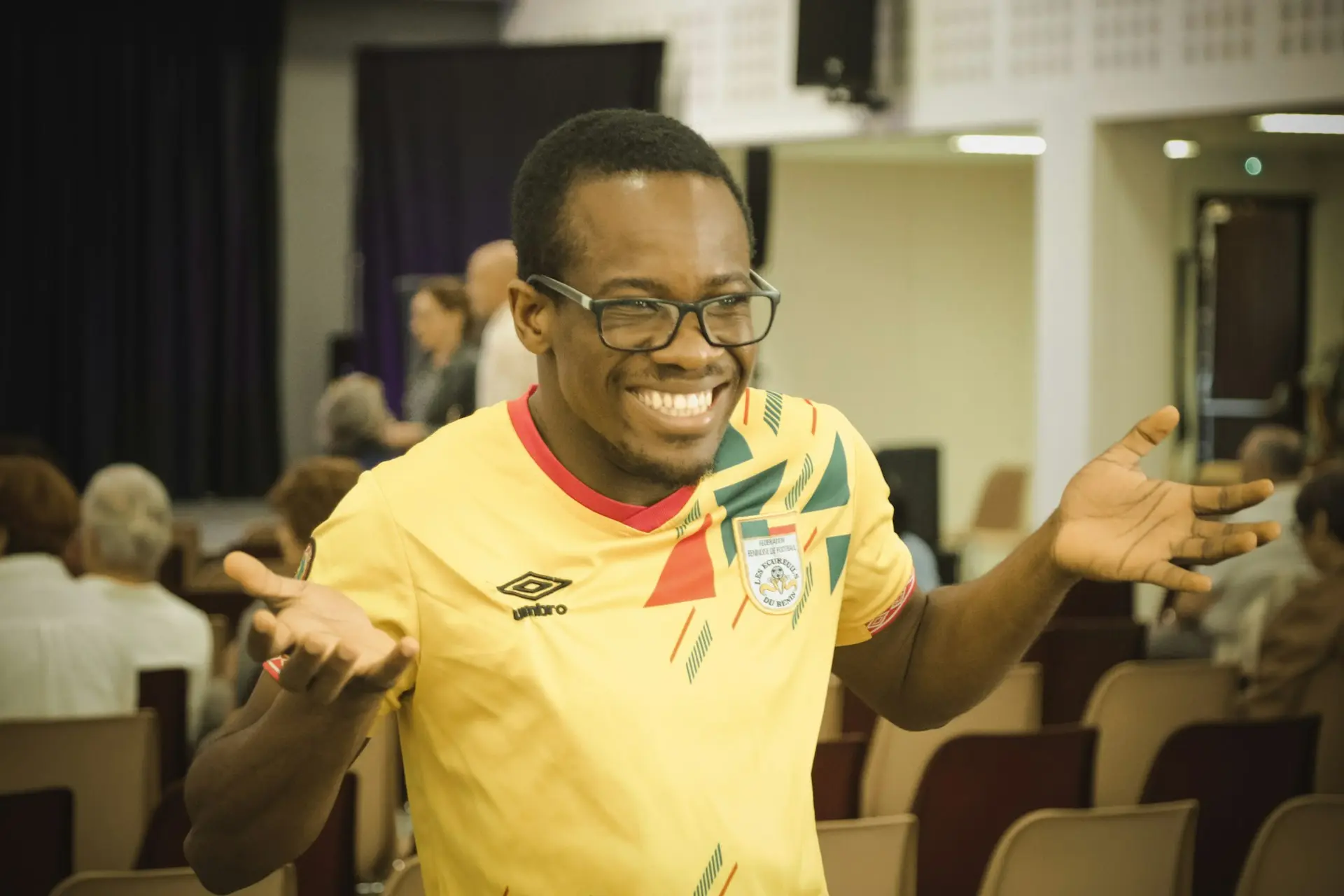 A man in a yellow shirt standing in front of a crowd